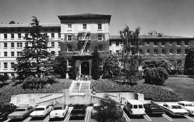 ID: photo of Cowell Hospital, a building with 5 floors and dual stairs leading to the main entrance