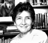  grayscale photo of Anita Madrid smiling against a background of bookshelves