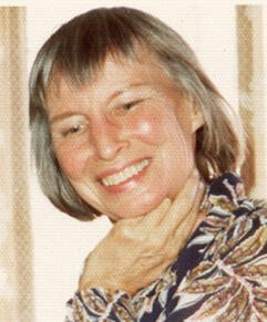  Helen Farnsworth in a white, black, and brown blouse; hand under chin; smiling slightly downwards into the distance