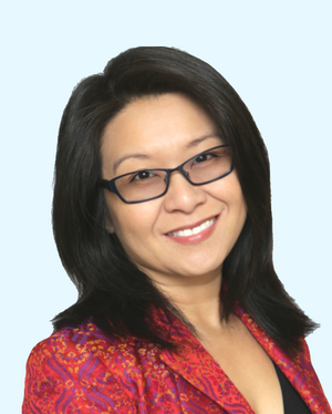  headshot of Lok Siu smiling in red lipstick, glasses, black top, and red patterned blazer against pale blue background 