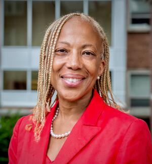  headshot of professor Lorraine Fleming in pearls and matching red blazer and blouse