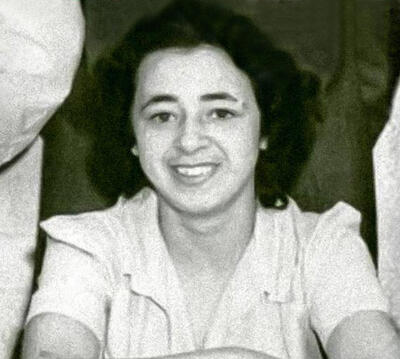  grayscale of Helen Powell smiling with arms crossed, wearing a white collared blouse